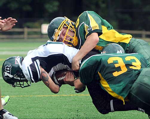 Windsor's #60 William Brewer and #33 Josh McKnight tackle Pitt Meadows ball carrier.