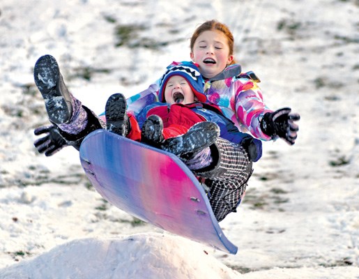 Grace, 12, and George, 3, Owen get airborne at Boulevard Park during the first snowfall of the year.