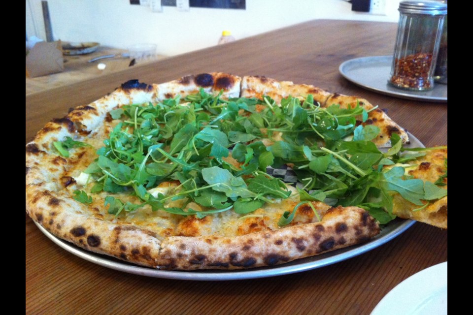 Cheese, caramelized onions and arugula pizza at Standard Pizza.