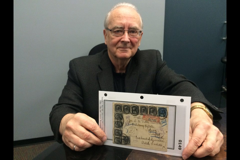 Ron Leith, stamp collector and auctioneer, with one of the items for sale this weekend at the Richpex show in Burnaby. Leith is holding a rare 1899 registered letter from Toronto, addressed to a tiny plantation town on the north-east coast of Sumatra, which is now Indonesia.
