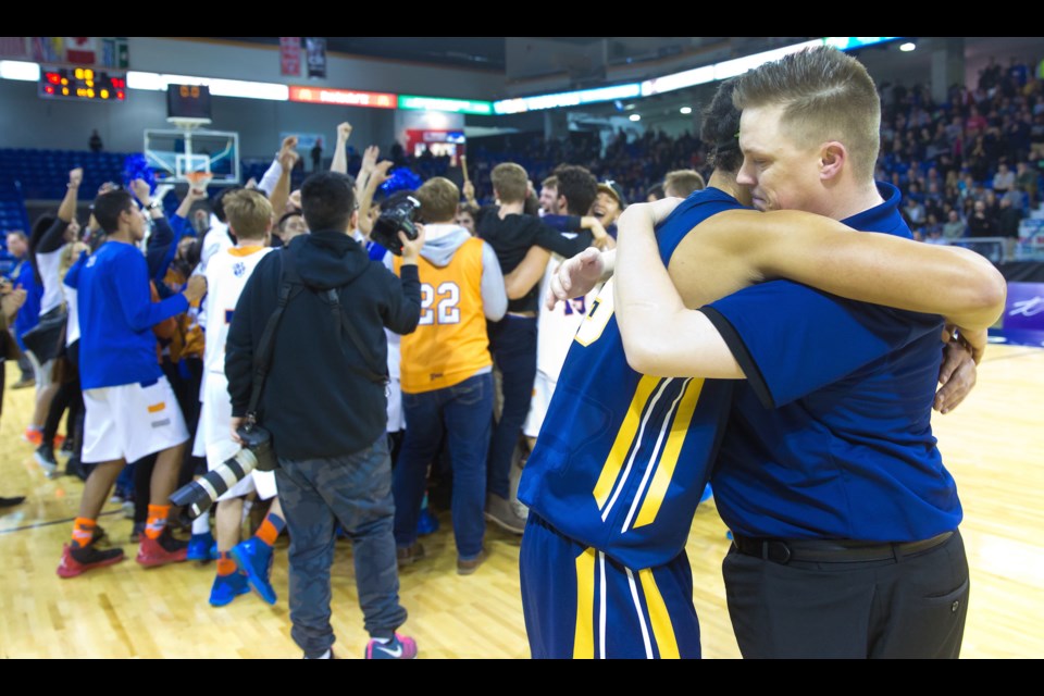 Steveston-London coach Mike Stoneburgh comforts Grade 12 star Nigel Boyd moments after Saturday's narrow loss to Southridge in the BC AAA championship game at the Langley Events Centre.