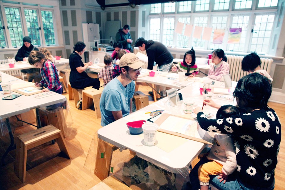 Families take part in a free In the BAG studio session at Burnaby Art Gallery, learning the “paint resist” technique.