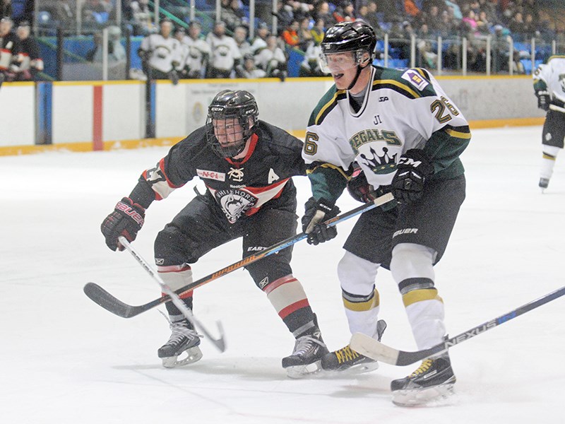 Powell River Regals forward Daniel Swanson battles a Whitehorse Huskies player Friday, March 11, in game one of second-round Coy Cup qualifying. Whitehorse won the series two games to one, eliminating Powell River from further playoff action. Swanson scored three times during the best-of-three series. Photo courtesy Whitehorse Daily Star