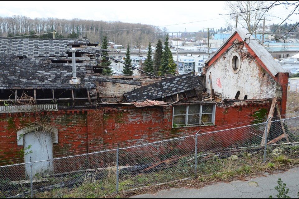 A wake-up call: Officials survey the damage at the Gas Works building on 12th Street, after part of its roof collapsed on Sunday afternoon. New Westminster firefighters and a representative from the province’s Ministry of Forests, Lands and Natural Resource Operations were quick to respond to the incident.