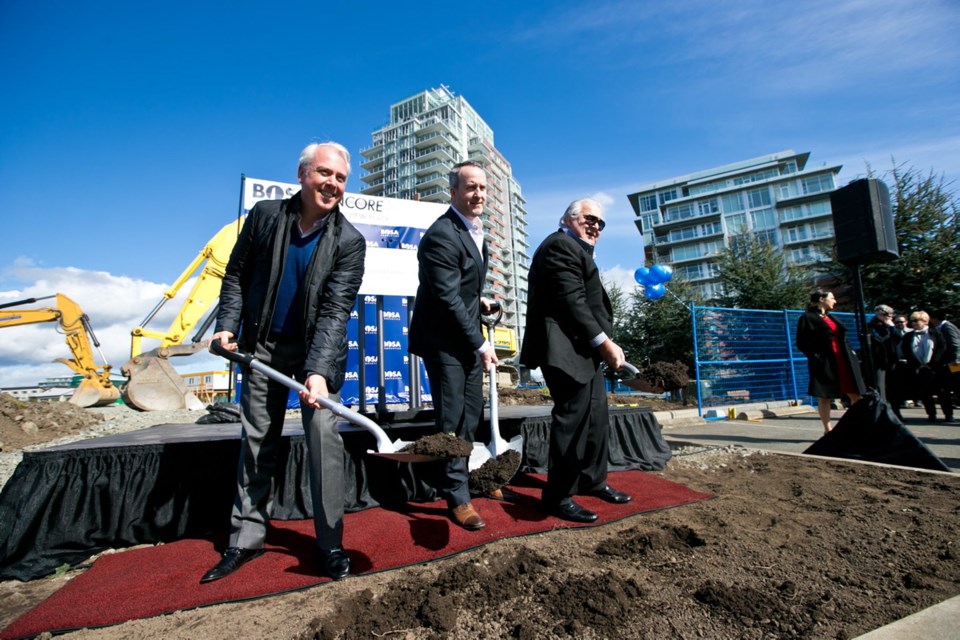 From left, Darrell Hurst, vice-president of leasing for Bosa Properties, senior vice-president Daryl Simpson and developer Ken Mariash shovel the first dirt to start construction on Bosa's Encore, a 17-storey condominium building at Bayview Place on the Songhees.