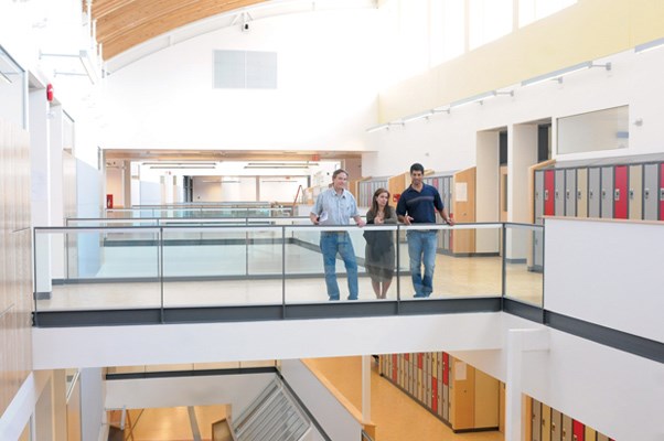 IAN Abercrombie (left), director of facilities for the North Vancouver school district, Franci Stratton, school board chair, and Karim Hachlaf, principal of Carson Graham secondary, look down from a third storey hallway.