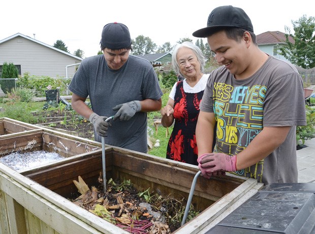 Society founder and Squamish Nation elder Barbara Wyss works with youth employees Sop7aoq (left) and Justin Leo at the composter. The society's projects aim to promote health and wellness in the nation and beyond.