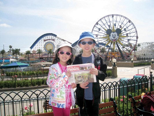 Christina and Alastair Quon sport hats and shades in the sun at Paradise Pier in Disney's California Adventure Park.