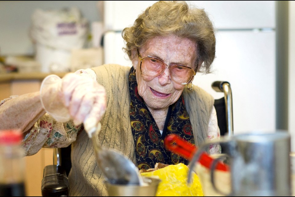 Aslaug Strom, 105, mixes up a batch of crisp coconut cookies at her Victoria Hill assisted living apartment. Strom, who moved to Canada from Norway in 1929, celebrates her 106th birthday on April 12.