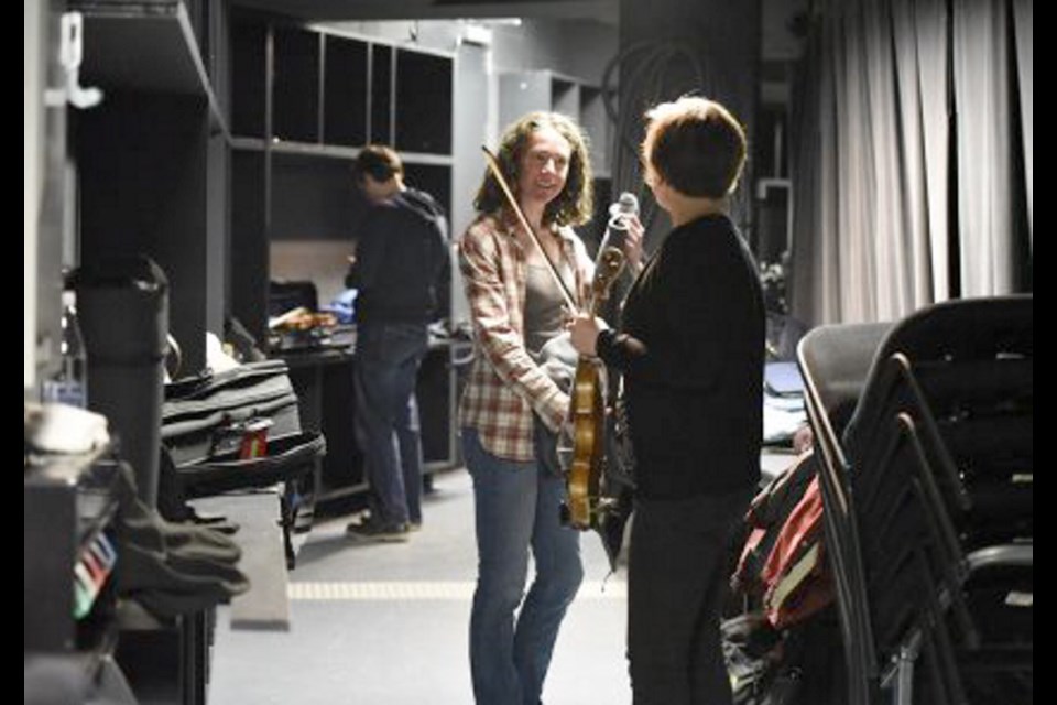 Victoria Symphony violinist Courtney Cameron, left, talks to assistant concertmaster (violinist) Christi Meyers, backstage before the rehearsal in Quebec City.