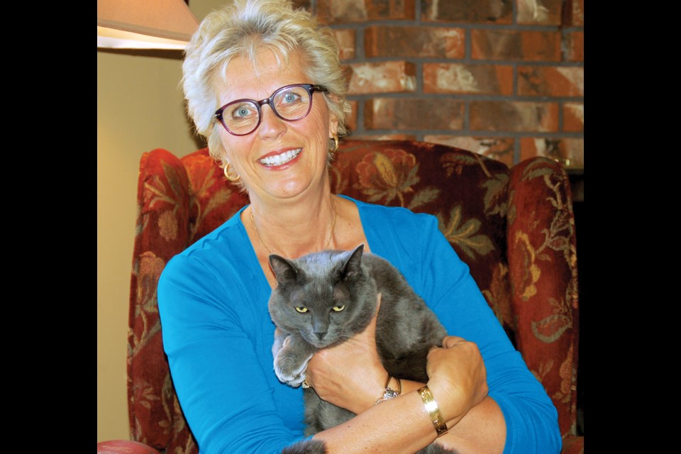 Colleen Haynes cuddles Polly, her 10-year-old cat, that was saved from a coyote’s jaws by two dogs in West Sechelt recently.