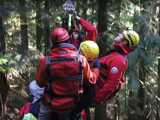 North Shore Rescue members prepare to be hoisted up with a patient who fell through the ice and spent the night on the edge of Mount Seymour. photo supplied