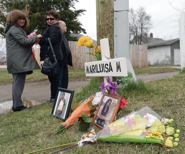 Family and friends gather Tuesday afternoon for a vigil for Marluisa Mycock whose body was found in an alley near Alward Street.