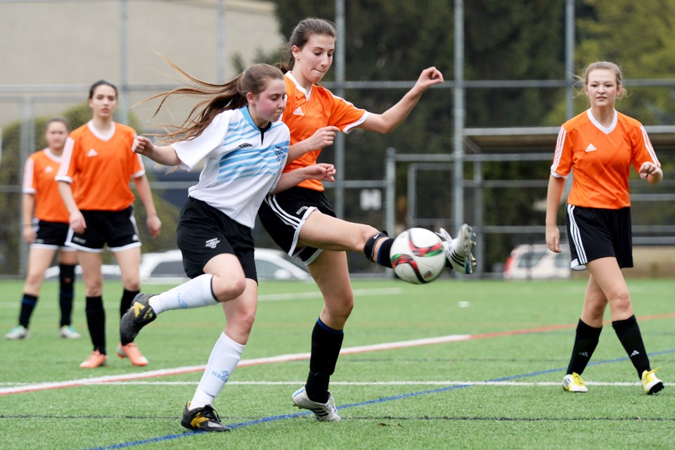 Kicking the ball away from her check is Royal City u17 Rebels' Sarah Forgie, centre. The Rebels beat North Shore to advance to the Coastal B Cup quarterfinals.