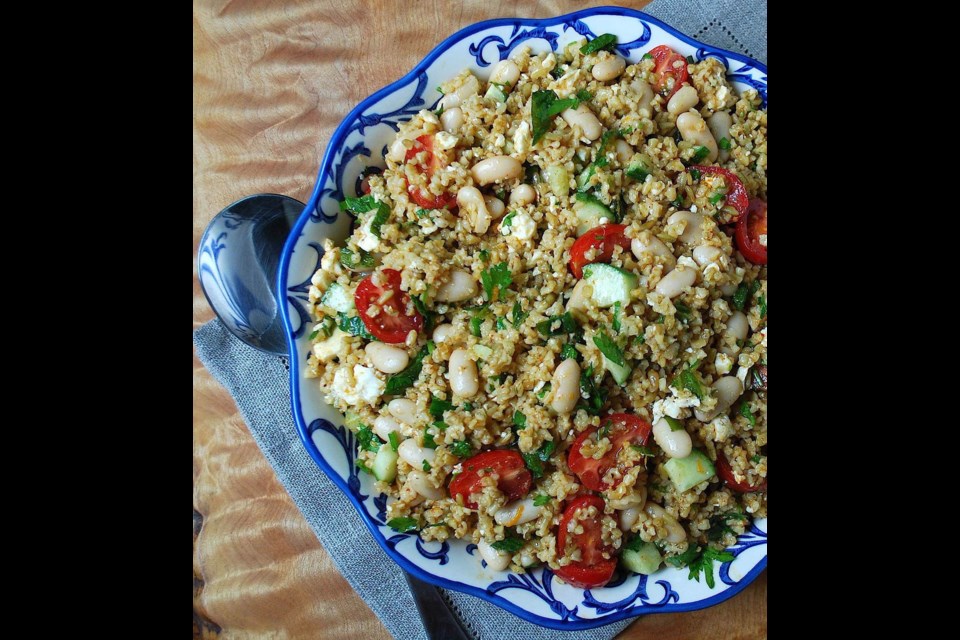 Freekeh cannellini bean salad with herbs, tomatoes and feta. High in fibre, freekeh is made by roasting and cracking immature and soft green wheat.