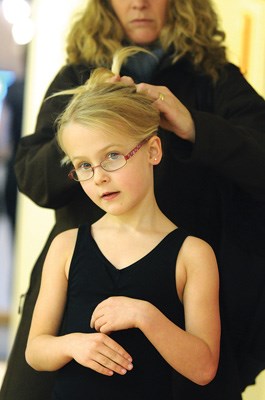 Claire Bacon (age 6) has her hair tied back by her mother before the Junior Dance Class begins.