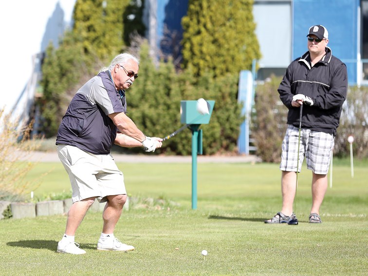 Mark Holick looks on as Ralph Posteraro tees off on Wednesday at Prince George Golf and Curling Club as men's day opens for the season. Citizen Photo by James Doyle April 13, 2016