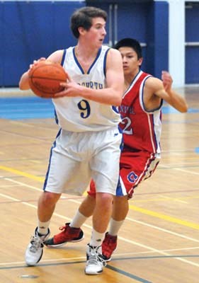Handsworth's #9 S.Engstrom (white) in action against Coquitlam's Centennial Secoandary (red) in Junior Basketball Tourney at Handsworth.
