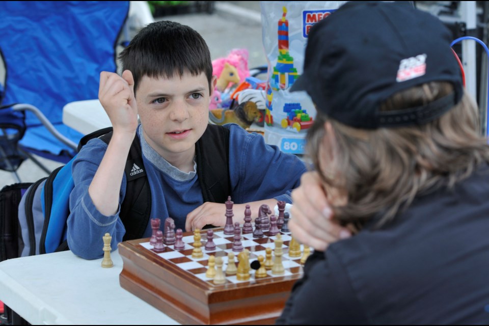Eli Johnston, 10, battles against his dad, Jon in a game of chess at the Burnaby Farmers’ Market last season. The market opens again for the season on May 7.