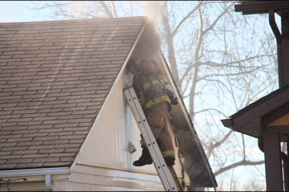 A fire fighter battles a stubborn blaze in the roof of the home, which may need to be torn down.