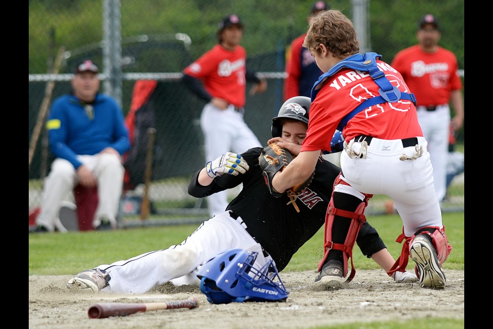 The Burnaby Braves’ Jack Yaremko applies a high tag on Victoria Red Eagles’ Dylan Brown during Game 1 of their bantam 15-under doubleheader on Saturday at Kensington Park. The runner was safe, and Victoria went on to win the opener 10-5. Burnaby exacted its revenge in Game 2 with an 11-0 shutout, thanks to a standout pitching performance from Williams Camacho-Soto.