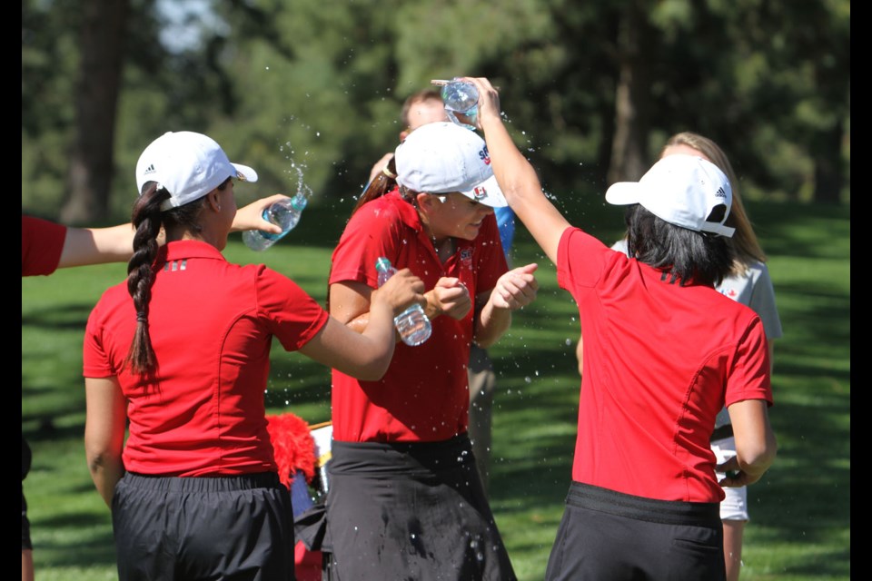 Simon Fraser University’s Michelle Waters, centre, celebrates with her teammates after winning the GNAC women’s golf title.