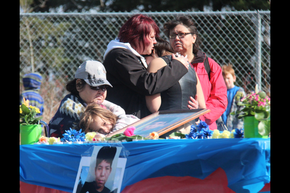 Jenny Poole (seated) comforts niece Blare Coss at a vigil for missing teen Denny Poole Monday. Beside them, Debbie Massee and Brittany, Poole's sister, pray for his safe return. Poole had been missing 44 days at the time of the vigil.