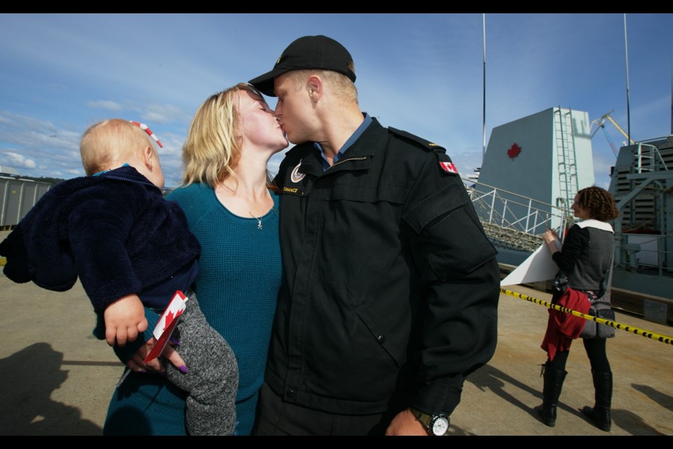 Ordinary Seaman Justin Swance kisses Brie Sanford as she holds their son, Greyson, at Canadian Forces Base Esquimalt on Friday, April 29, 2016. Swance was at sea for 2 1/2 months on HMCS Saskatoon in support of Operation Caribbe.