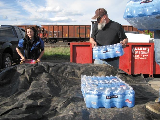 Rod Duerksen, right, and several other donors load supplies into a trailer.