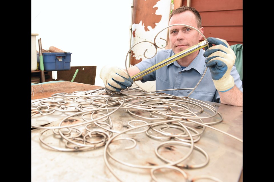 Artist Bruce Voyce peers through a stainless steel heart that will form part of his work, Love in the Rain, the designated “love lock” installation chosen by the Vancouver Park Board for Queen Elizabeth Park. Photo Dan Toulgoet