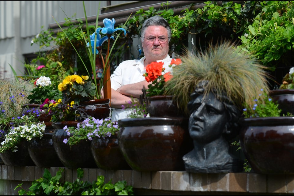 Maryann Wadge and Kevin Gilbraith, shown, have sought to enhance their home by creating a garden oasis on the patio, but their building’s strata council has ordered them to remove the planters.