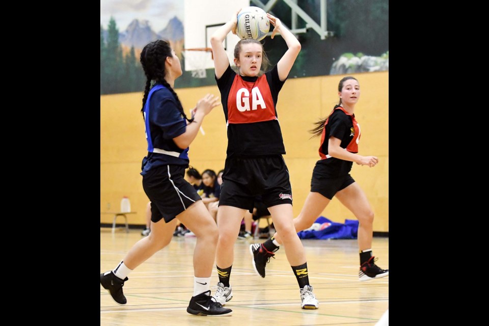 Burnaby South’s Callie Glover, wearing the GA bib, looks to pass while teammate Brianna Martint, back right, moves into position. Defending is Alpha’s Joanna Luc.