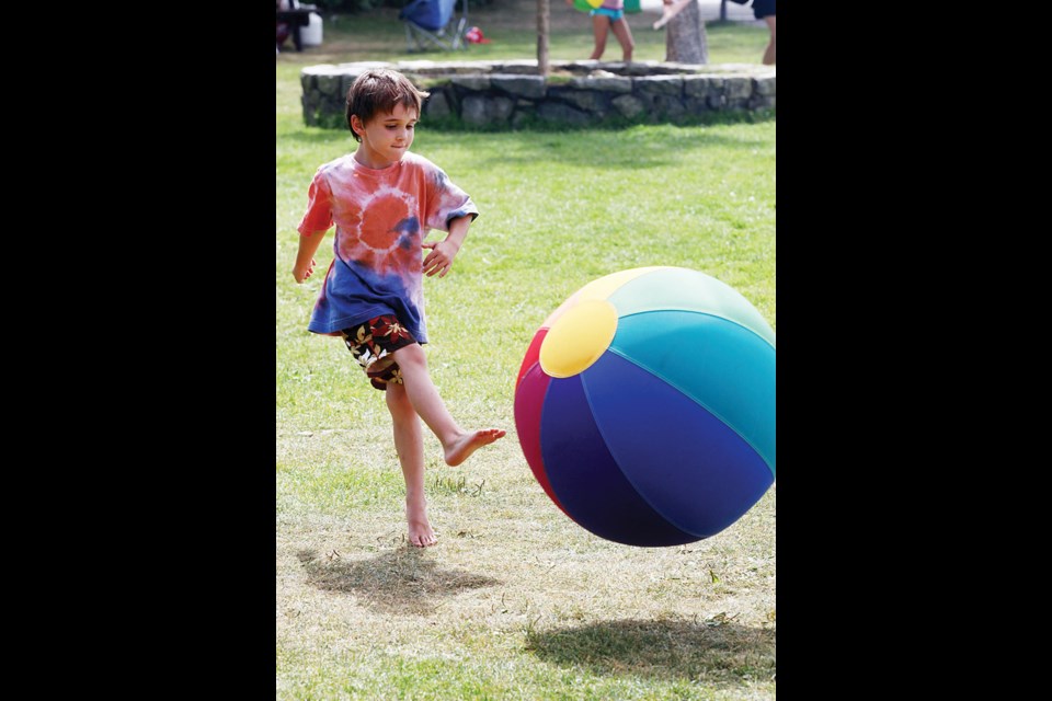 Connor Chisholm kicks a giant beach ball at Ambleside Days.