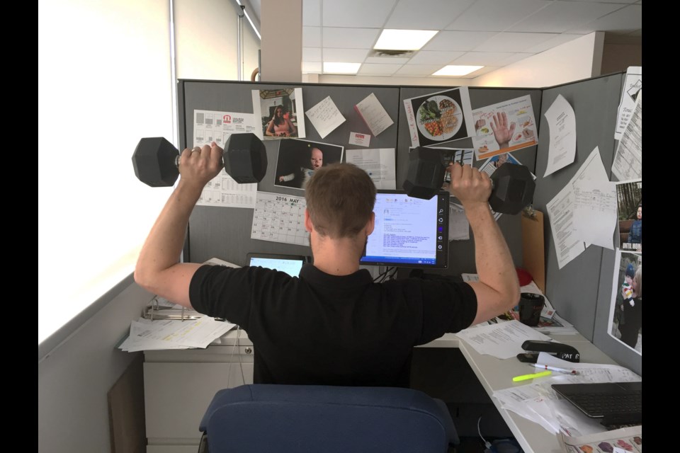 Who needs a gym? Team Après Ski’s Collin Neal sneaks in a workout session at his desk which has contributed to his 12.5 lb. loss since the News’ Fitness Challenge began two months ago. Photo by Lesley Smith