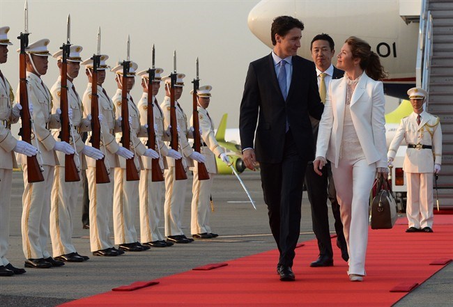 Prime Minister Justin Trudeau and wife Sophie Gregoire Trudeau are greeted by an honour guard as they arrive in Tokyo, Japan in May. The Trudeaus will be in Victoria to greet the Duke and Duchess of Cambridge on Saturday. THE CANADIAN PRESS/Sean Kilpatrick