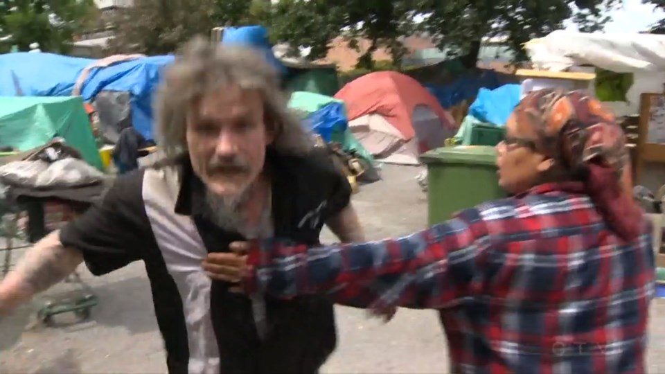 A man at the tent city lunges toward a cameraman who recorded the encounter. - photo