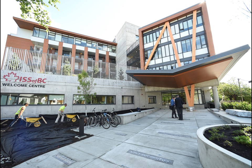 Plaques, written in different languages, are set into the concrete along the entrance to the complex. The translation of each is "welcome." Photo Dan Toulgoet