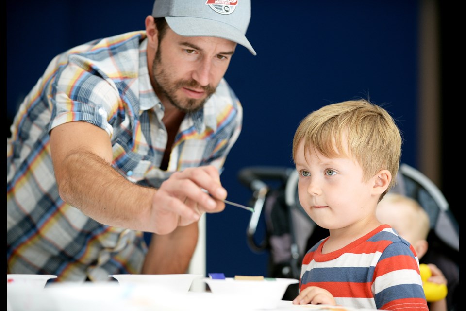 Rory Dolinski works with four-year-old Zakir at the ArtsToGo workshop on Sunday.
