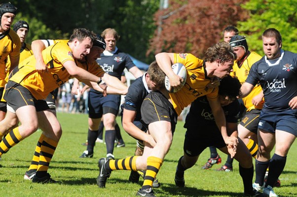 Capilano player, Mike Langley charges forward with the ball with Jesse Ryan right behind him.