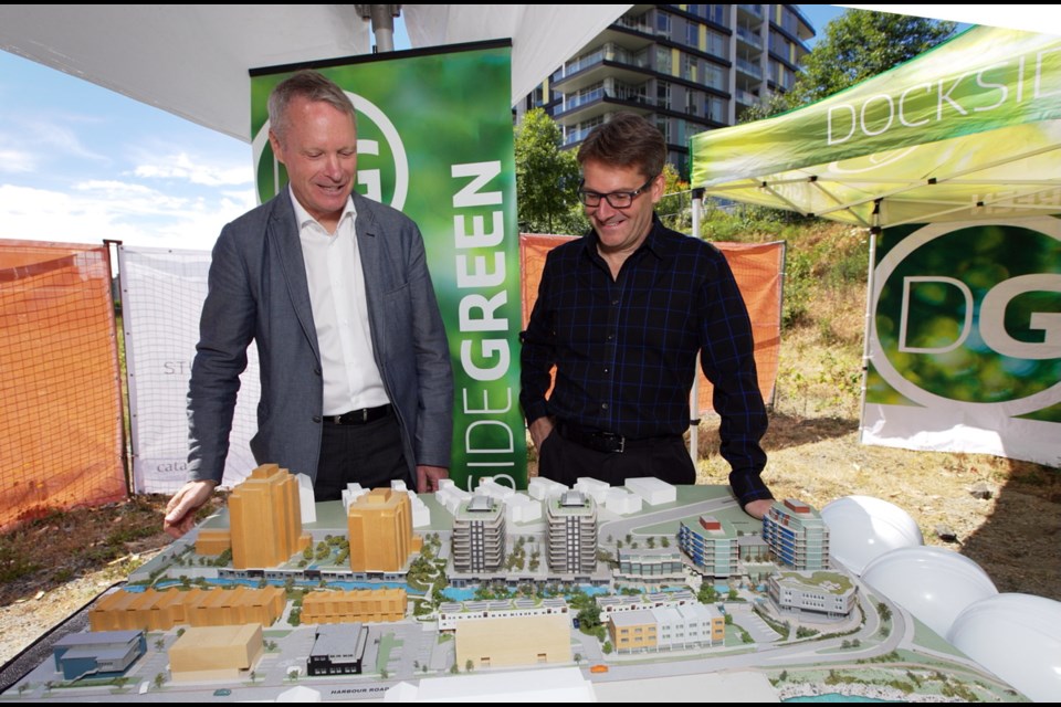 Norm Shearing, left, president of Dockside Green, and Robert Brown, president of Vancouver's Catalyst Community Developments Society, review a development model at a groundbreaking ceremony for the Madrona complex in June 2016.