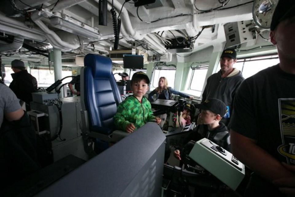 Five-year-old Arrow White sits on the bridge during a tour of HMCS Winnipeg at the West Shore Navy Day open house on June 11.