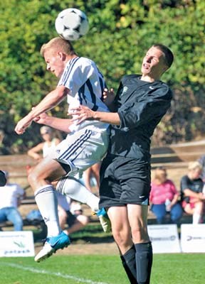 Capilano Men's Blues #18 Devon Wooley (white) beats a Quest University player to a header ball during action over the Thanksgiving weekend.