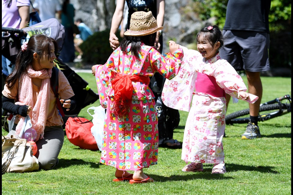 Nanami Iwata, 5 (at left), and Kotone Otsuki, 3, dance together.