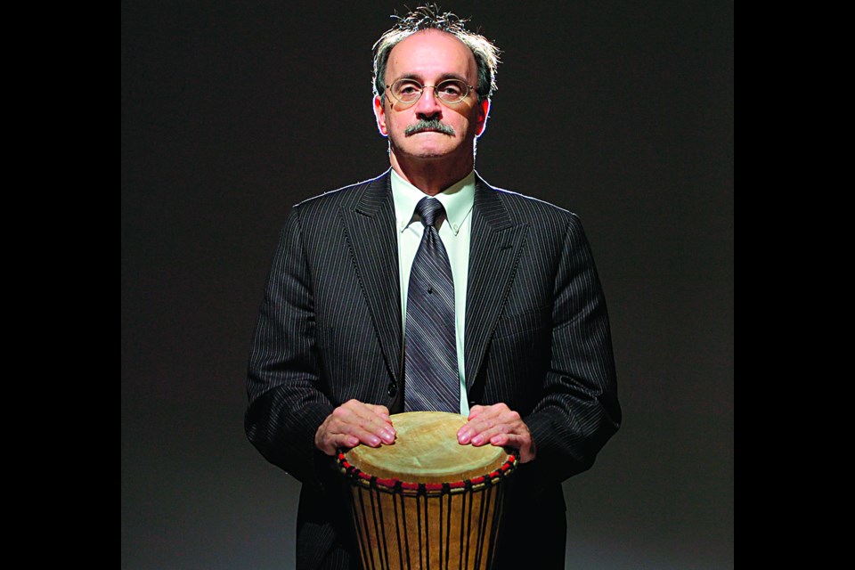 Dennis Watt happily banged the drum while looking glum for a 2007 cover story on corporate drum circles. Photo Dan Toulgoet