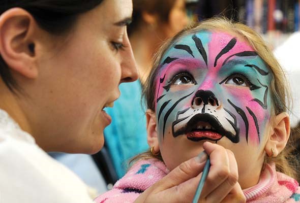 6-year-old Donatella Busa has her face painted by artist Josianne Bedard in the children's section of the library.