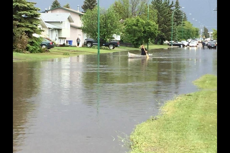 In Prince Albert, Sask., a canoeist paddles along a residential street.