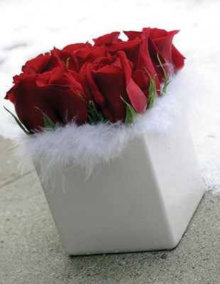 A dozen red roses and a white boa make for a floral arrangement worthy of Santa.