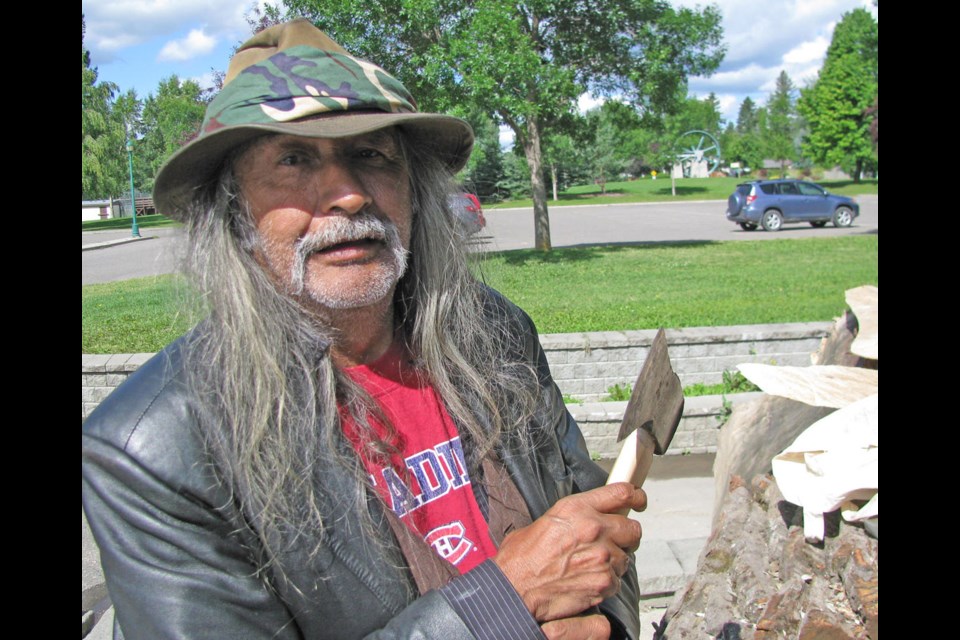 Robert Frederick talks about his ax as he prepares to work on the dugout canoe that will become part of the exhibit at The Exploration Place called The Path of Our Paddle.