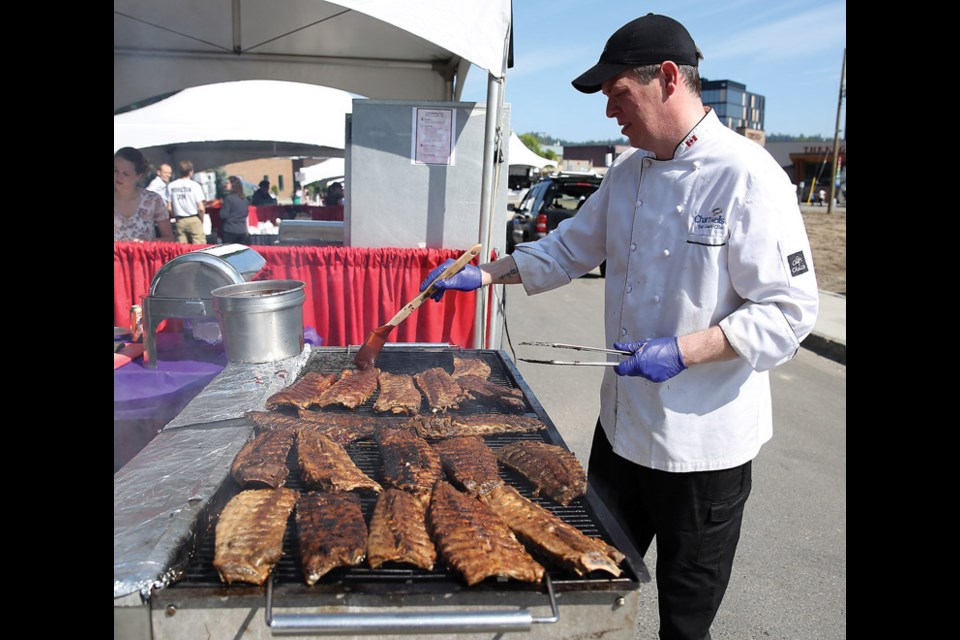 Matt Stevenson prepares barbecue ribs at the Chartwell Foodservices UNBC booth in the Canadian Western Bank Taste Pavillion on Sunday as part of Downtown Summerfest. Citizen Photo by James Doyle July 17, 2016