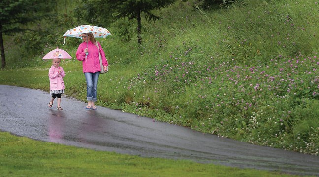 Ella Brunsdeon, 5, and Kathy Fox stay dry under their umbrellas Thursday morning as they walk by Connaught Hill on their way to the dentist. Citizen photo by Brent Braaten July 14 2016